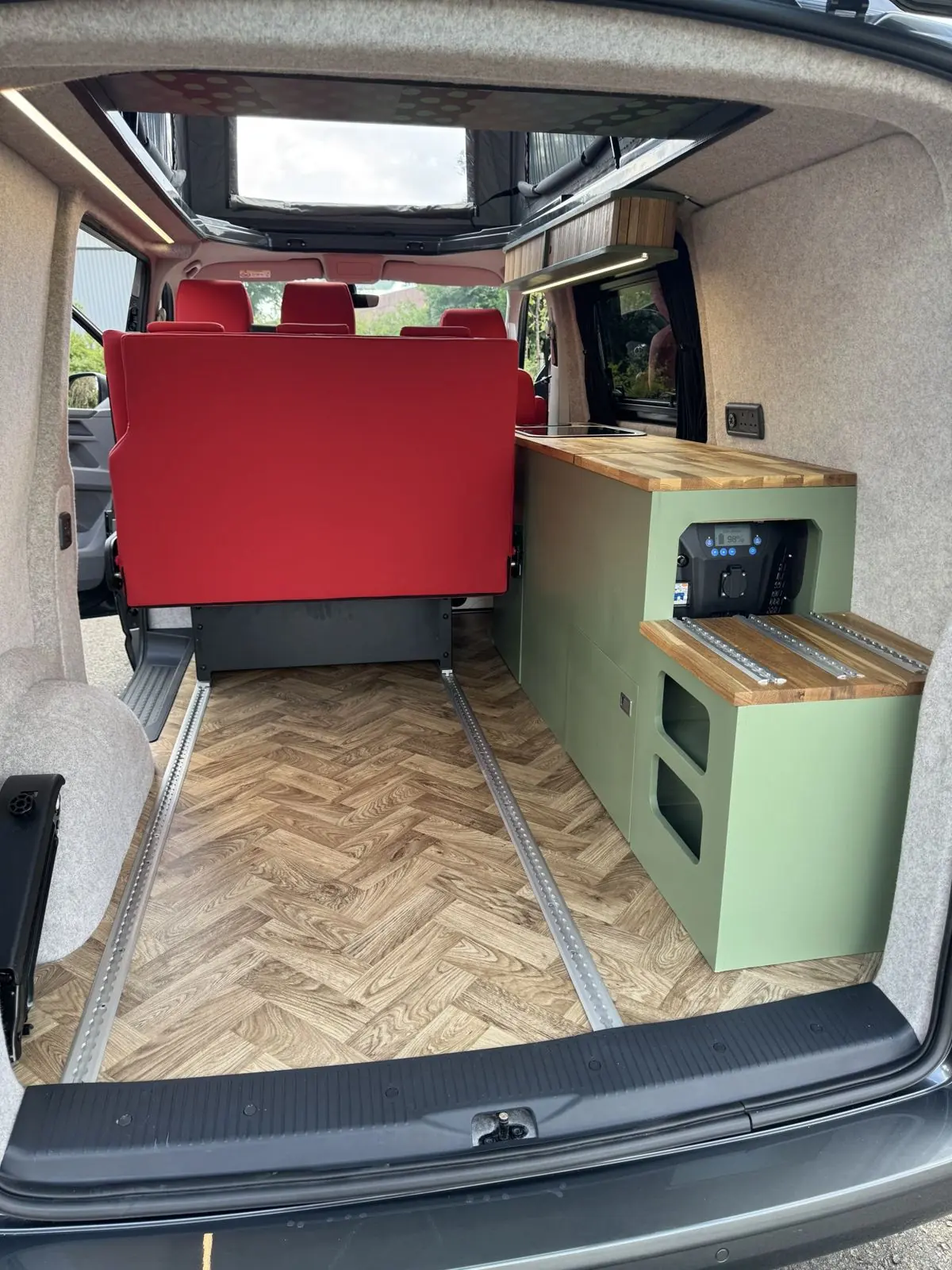 View from the tailgate of a build with red quilted seats and a herringbone floor