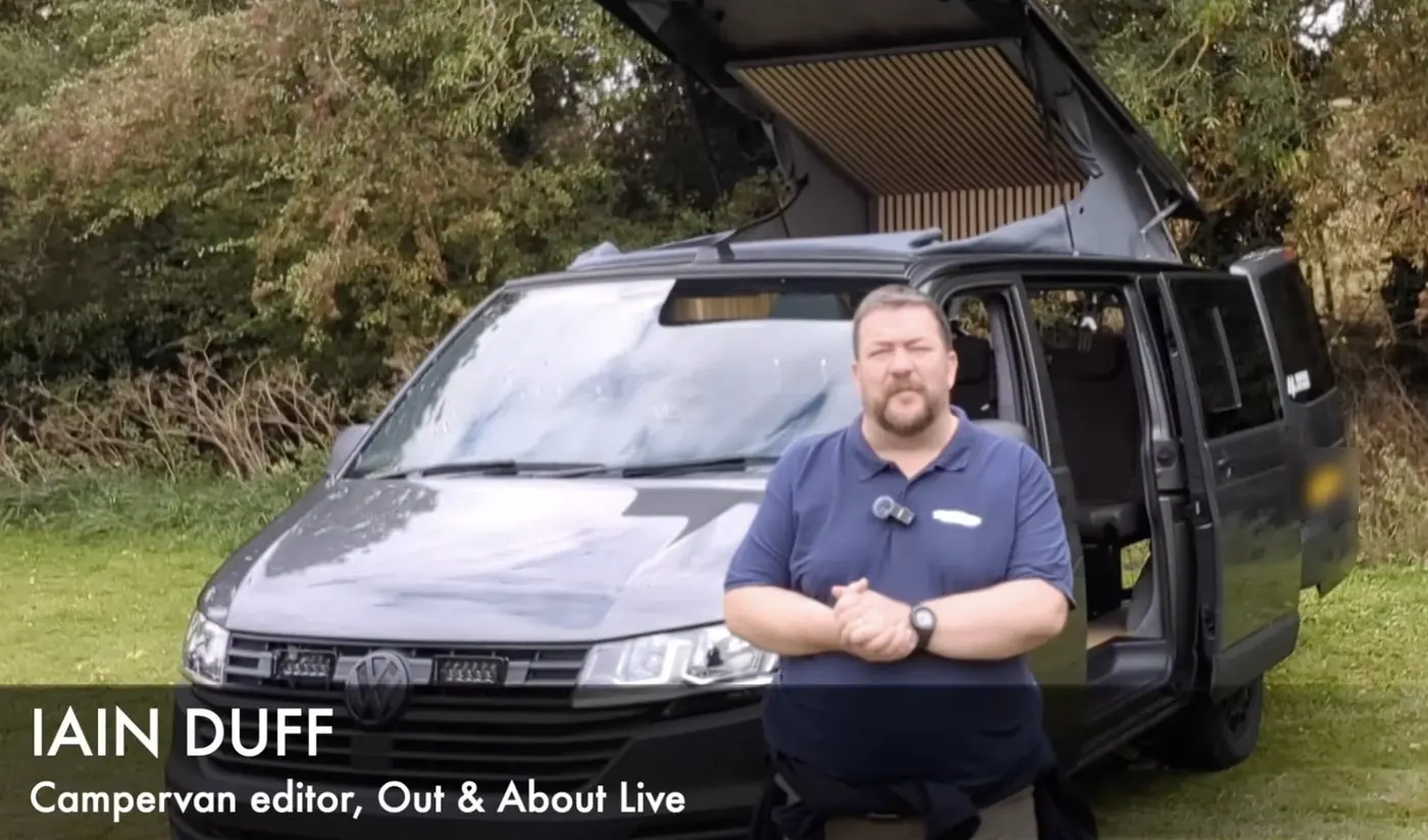 Iain Duff, campervan editor at Out & About Live, presenting his review in front of a Maverick Expedition with the pop-top raised